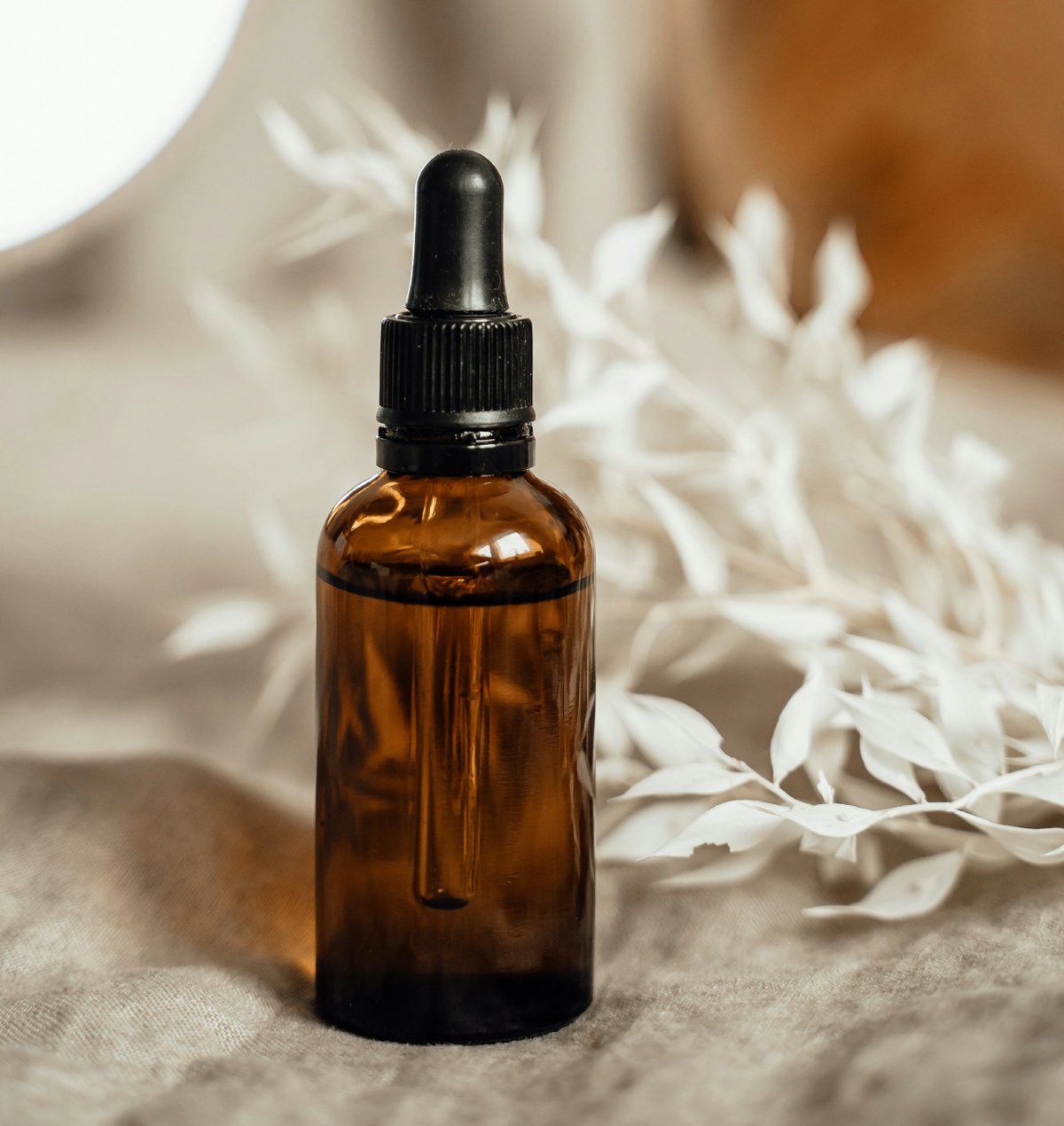 Dunkle Apothekerflasche mit Pipette und natürlichem Öl — zentrale Zutat für DIY-Feuchttücher