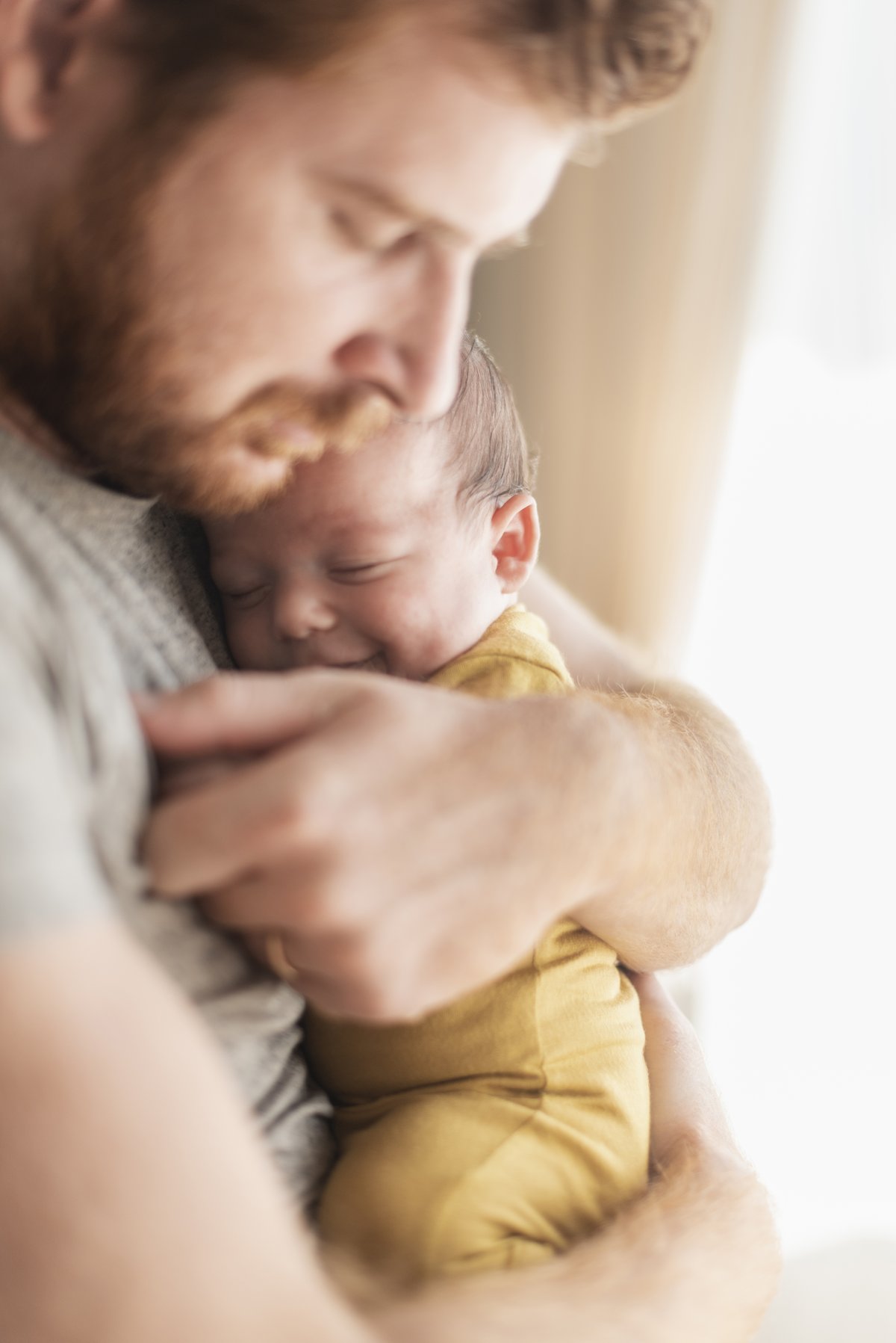 Vater trägt sein Baby in einer Komforttrage am Körper — Bindung im Alltag
